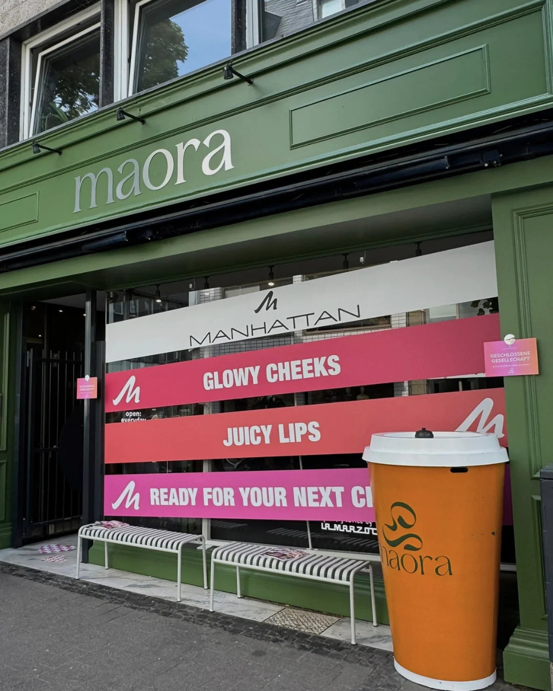 Maora Café mit Manhattan Branding im Schaufenster und übergroßem Matcha Becher davor