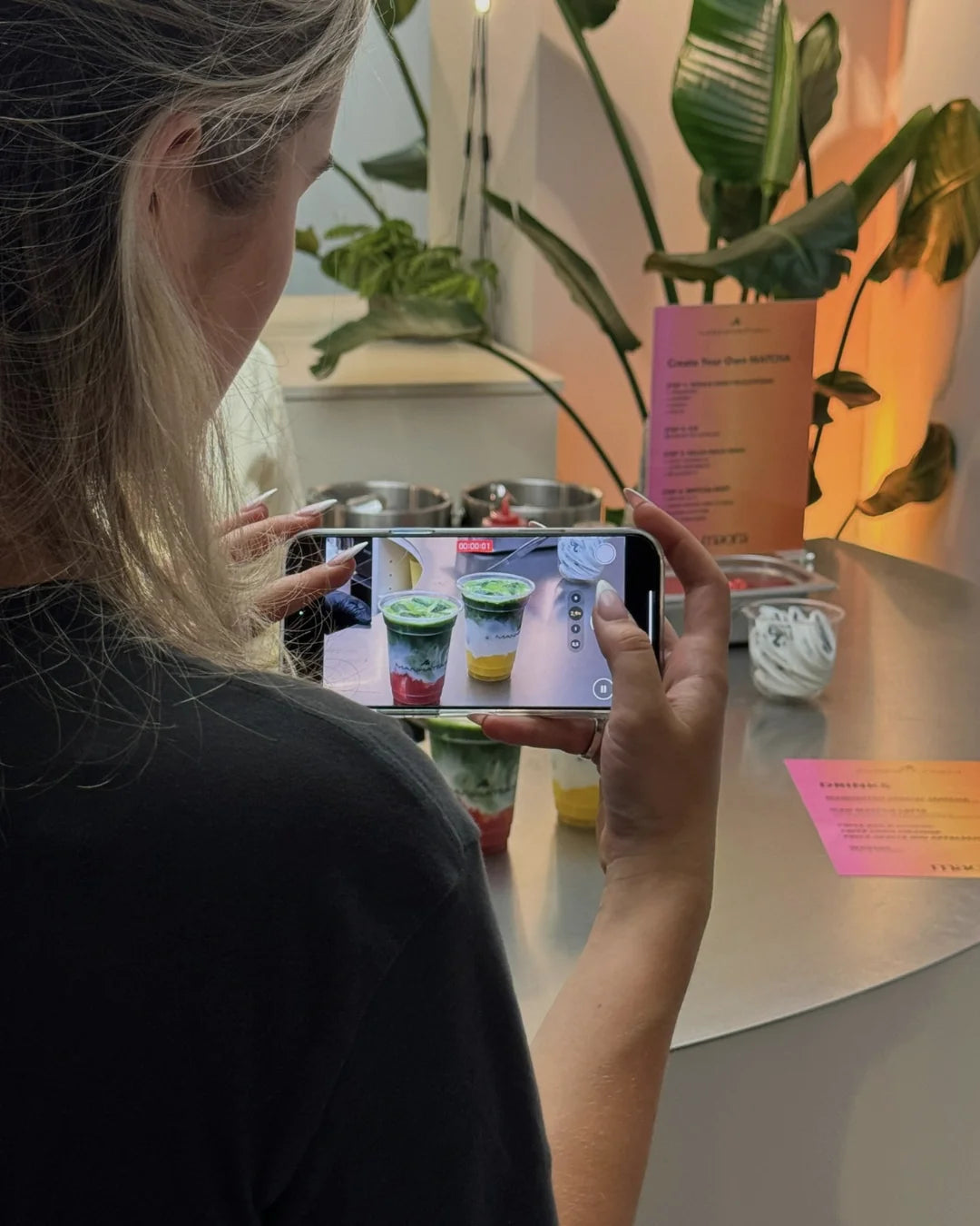 Gästin fotografiert bunte Matcha Drinks von Maora mit dem Smartphone