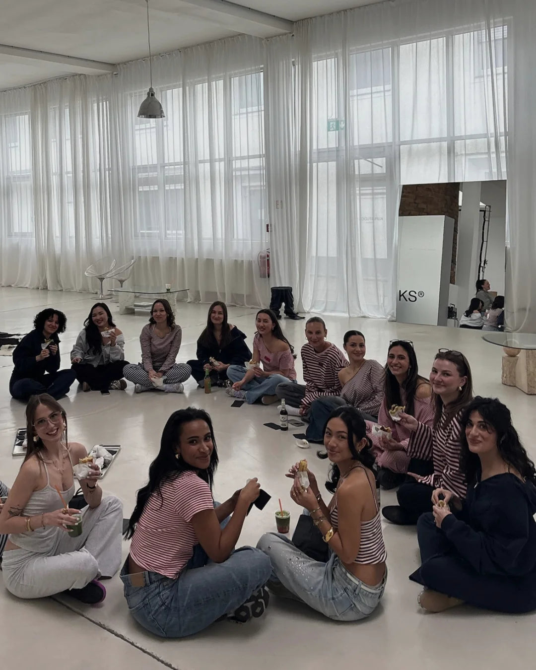 Gruppe sitzt nach einem Event mit Matcha Drinks von Maora im hellen Studio zusammen