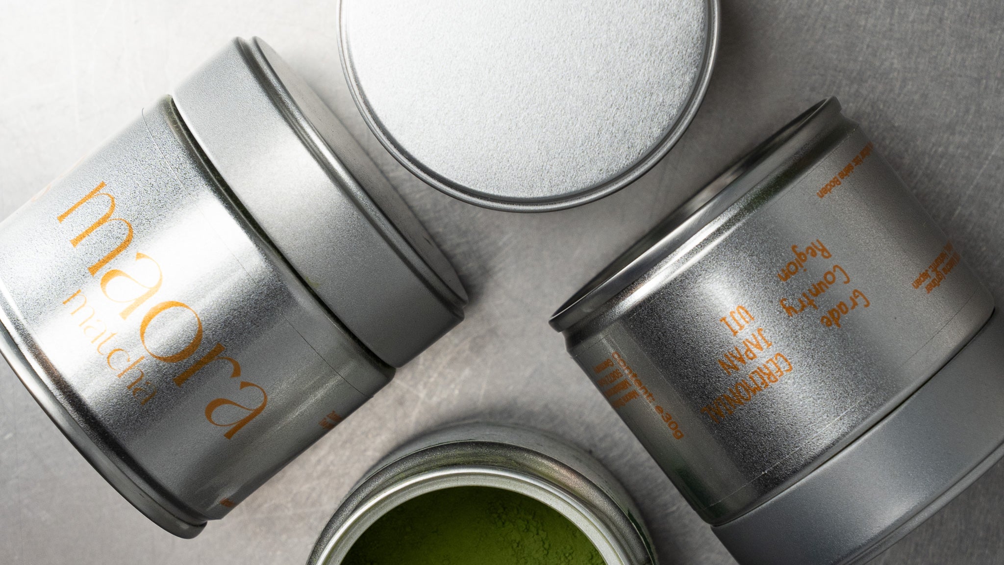 Maora Matcha Dosen in verschiedenen Ansichten mit geöffnetem Matcha Pulver