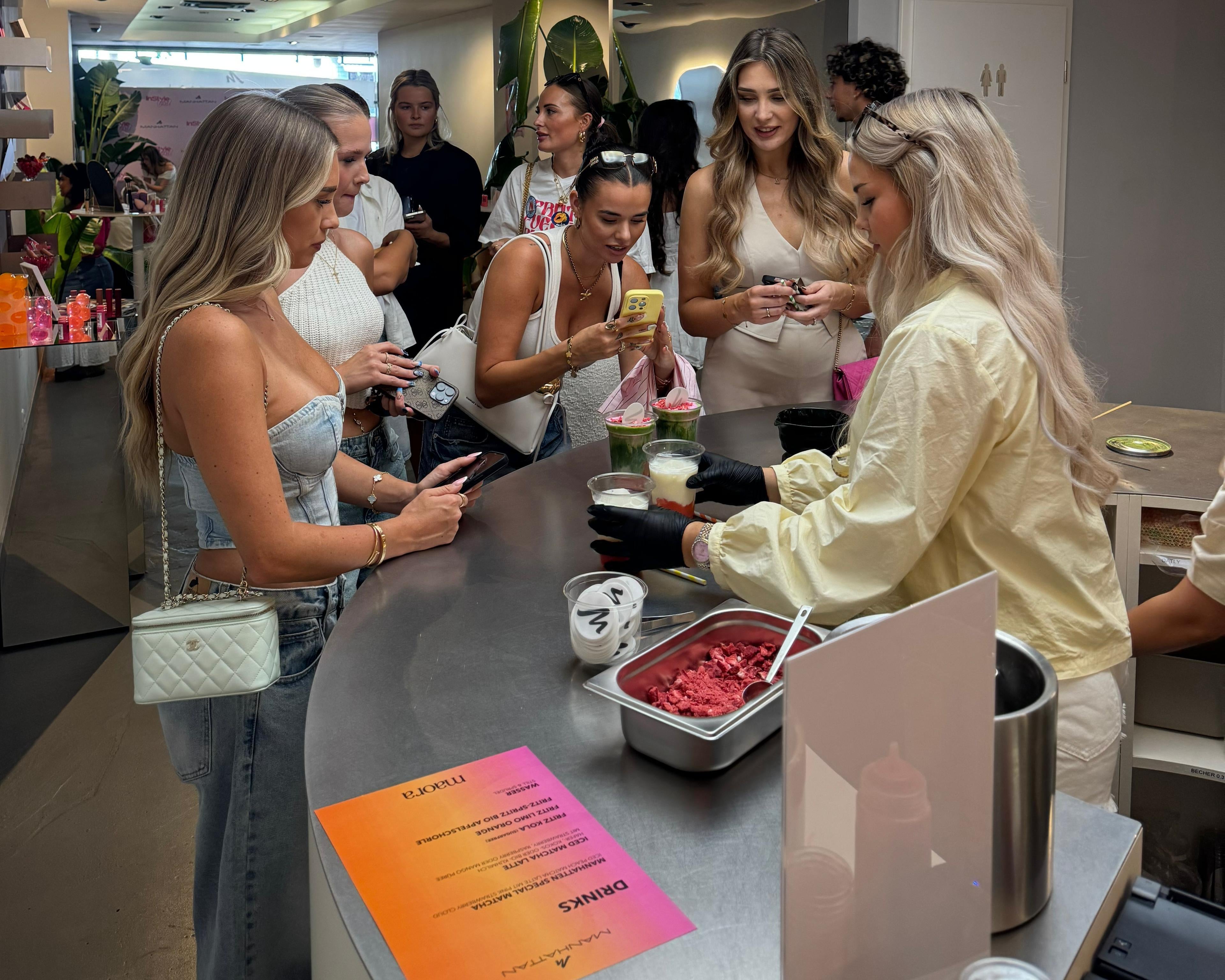 Gäste im Maora Matcha Café in Köln erhalten auf einem Event frisch zubereitete Matcha Drinks an der Theke